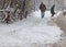 People walk on a very snowy sidewalk during snowstorm in the city of Sofia, Bulgaria â€“ feb 26,2018.