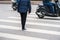 People walking across a street while motorbikes keep running on street in Hanoi, Vietnam. Closeup