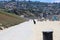 People walking along a smooth concrete bike trail along the beach with people relaxing and playing in the sand