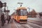 People walking along a tram driving on Warsaw streets in Poland on a cloudy day