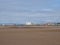 People walking on the beach at blundell sands in crosby near southport merseyside with building and liverpool docks in the