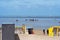 People walking on the beach in Cuxhaven at low tide. People in the water on the North Sea