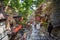 People walking down the narrow urban street with shops in Iran