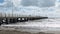 People walking on Forte dei Marmi`s pier while big waves lurk on the beach