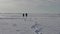 People walking by the frozen snowy lake