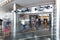 People walking inside of the mall in the Petronas twins tower and two formula one cars.