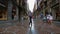 People walking on narrow streets with attractive glass shop windows in Bilbao