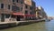 People walking old street with cafe along canal, slow-paced life in Venice