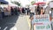 People walking on outdoor street farmers market. Vendors sell locally produced goods, California USA