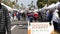 People walking on outdoor street farmers market. Vendors sell locally produced goods, California USA