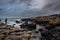 People walking over the natural hexagonal stones at the coast called Giant`s Causeway, a landmark in Northern Ireland