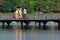 People walking over a wooden brigde