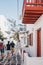 People walking past building with colourful detail on a narrow street in Hora Mykonos Town, Greece