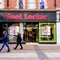 People Walking Past High Street Retailer Foot Locker Store During COVID-19