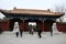 People walking past the lions at the entry gate to Jingshan Park