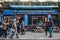 People walking past shops and cafes on Broadway Market, London, UK