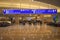 People walking, and resting with bagagges.  Gates , Parking ,Ticketing  and Check-in sign at Orlando International Airport.