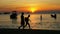 People walking on sea beach against sunset sky