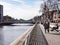 People walking and sitting on the Liffey Boardwalk in Dublin, Ireland.