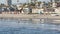 People walking strolling. Pacific ocean, sea water wave. Beachfront vacations resort. California USA