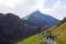 People walking to the summit of a mountain through a pathway surrounded by beautiful landscapes in Snowdonia, Wales