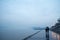 People walking with umbrellas near the Danube river during a heavily foggy and rainy winter afternoon in Zemun, Belgrade, Serbia