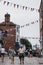 People walking under the colourful bunting on a street in Lymington, New Forest, UK