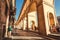 People walking under historical arches of narrow streets of ancient Tuscany city