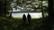 People Walking Under Tunnel Of Tree Branches