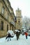 People walking under an unusual snow in front of the Clocktower of Tour de l`Horloge, or clock tower, on the Hotel de Ville