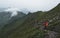 People walking up a steep mountain hiking path covered in fog and rain ridge walk, swiss alps brienzer rothorn