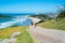 People walking on uphill track on Mount Maunganui with endless beaches stretching out to blue horizon