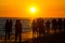 People walking on waterfront on sunset