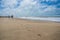 People walking on a white sand beach on a gloomy day