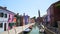 People walking on wonderful street with multicolored houses in Burano, Venice