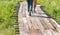 People walking on the wooden bridge in flowers field