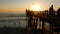 People walking, wooden pier in California USA. Oceanside waterfront vacations tourist resort.