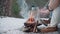 People are warming their hands by a campfire in the woods in winter