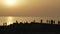 People watch the sunset near the ocean.