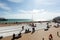 People are watching a performance of a puppet theater in Brighton, beach chairs