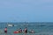 People watching sea gulls follow a fisherman`s boat