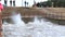 People watching water raging on dam during spring flood. Flooding river during melting of snow