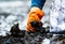 People wear orange gloves picking garbage up in to white bag. Closeup hand of adult volunteers collecting black garbage on the sea