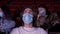 People wearing blue medical masks in times of coronavirus epidemic, watching movie at the cinema. Media. Portrait of a