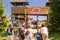 People at the Western City park entrance with wooden towers and retro entry board.