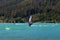 People windsurfing and kite surfing in a lake during a sunny summer day