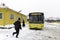 People and yellow public bus on a snowy winter day