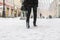 peoples legs with boots walk in snowy day. fashion concept in the city street f