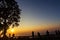 Peoples and trees silhouetted with sunset