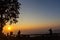 Peoples and trees silhouetted with sunset